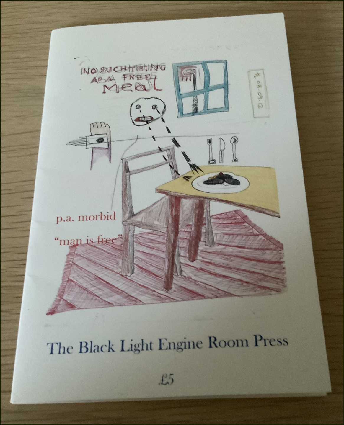 This is a photo of the pamphlet lying on a wooden surface. The jacket is white and most of it's taken up with a colour drawing done roughly, like a doodle really. It's a cartoon. It is a rough drawing of a room with table, chair and window. There's a meal on the table (maybe sausages on the plate), and the cutlery standing up vertically. There is a face with clenched teeth and tears dropping onto the table like two lines of black hyphens. Words above the head in scribbly unclear caps say: THERE'S NO SUCH THING AS A FREE MEAL. The author's name in pink lower case (same colour as the carpet) appears in the middle of the jacket left-justified, with the pamphlet title just below. An inch from the bottom on bold lower case is the title of the press: The Black Light Engine Room Press.