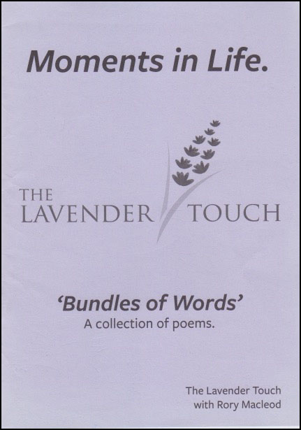 Mauve coloured jacket with black print mainly centred. Title at top large lower case reads Moments in Life. In the middle in caps THE LAVENDER TOUCH with drawing of a sprig of lavender. Below this, smaller, and inside single inverted commas, 'Bundles of Words', and below that even smaller A collection of poems. Author's name very small bottom right hand corner.