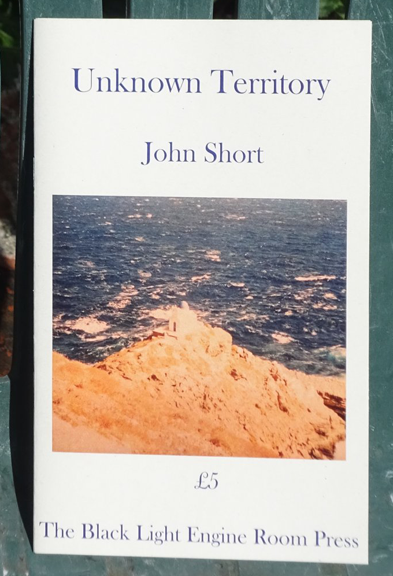 This is a colour photograph of the pamphlet against a green background, maybe a garden chair. It is white, with title and author's name in lower case dark font, centred in the top third. Below this a colour photograph of a spit of soft sand reaching into the sea. Below this the price, centred, and the name of the press.